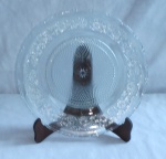 Prato para bolo em demi-cristal translúcido adornado com perolados e flor de lis em baixo relevo, com bordas em curvas. Med 30cm diâm