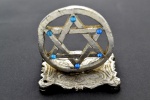 Estrela de Davi - Pequeno Objeto Decorativo de Mesa em metal Prateado. Possui em cada ponta pedrinhas em azul. Medida: 5 x 5 x 4 cm.