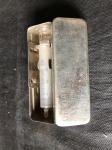 Uma caixa de inox com seringa da marca DELTA, conforme imagem