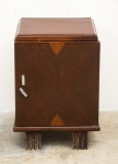 Criado mudo Art Deco em madeira nobre, com uma porta e puxadores em metal trabalhado, medindo 47 x 32 x 32 cm.