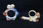 COLECIONISMO - Lote de 2 porta guardanapos em porcelana alemã. Arlequim e crianças Maior 5x12 cm e menor 9x9 cm.