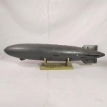 MILITARIA - Zeppelin da Marinha Americana USS AKRON ZRS-4 - Miniatura em plástico. Mede aproximadamente 45 centímetros de comprimento. Acompanha suporte plástico original.  O USS Akron (ZRS-4) foi um dirigível da Marinha dos Estados Unidos entre 1931 e 1933. Foi a primeira aeronave do mundo construída com o propósito que servir como nave-mãe, levando consigo aeronaves parasitas. O seu caça parasita era o Curtiss F9C Sparrowhawk, que podia ser lançado e recolhido em pleno voo. Falta uma pequena hélice e duas delas estão com apenas uma pá,