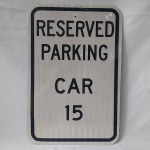 Maravilhosa Placa de Trânsito Americana, adesivada, em metal e sem uso, com os dizeres RESERVED PARKING CAR 15 (ESTACIONAMENTO RESERVADO PARA O CARRO 15). Medidas aproximadas 46 x 30,5 centímetros.