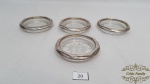 4 Descansos de Copos  em Vidro com Bordas em Prata 90. Medidas: 9 cm de diametro.