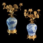 Par de candelabros em bronze ormolu e faiança de manufatura europeia, decoração em chinoiserie. Europa, segunda metade do Séc. XVIII. 38 cm de altura.