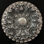 Salva em prata fundida e cinzelada, com marcas de ourives e J. Coroa. Portugal, Séc. XIX. 1.900 Kg. 49,5 cm de diâmetro.