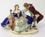 Escultura em porcelana representando casal com violoncelo. Scheibe-alsbach. 15 cm de altura. (Pequenos bicados).