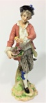 Escultura em porcelana representando rapaz com cesto de flores-real. Viena. 26 cm de altura.