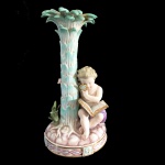 Meissen. Grupo escultórico em porcelana representando criança com lupa e vidro. 21 cm de altura. (Apresenta restauro).