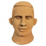 Escultura em barro representando cabeça de homem. 29 cm de altura.