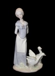 Belíssima Estatueta em porcelana representando dama com pato , estilo ladró. med. 30x17cm.
