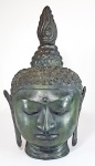 Antiga cabeça oriental em bronze com pátina esverdeada, repres. rosto de Buda em contemplação. Feita pelo método de cera perdida. Resíduos da terracota no interior. Séc.XIX/XX. Med. 35 x 22 x 16 cm.