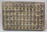 Placa mexicana em terracota decorada com várias caveirinhas em relevo ao gosto Azteca. Med. 27 x19 cm.