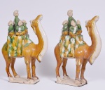 Par de esculturas em cerâmica vitrificada, ao gosto da Dinastia Tang, representando Camelos com Dignatários, altura total 36 cm.
