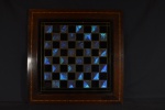 Tabuleiro de xadrez preto e azul feito com asa de borboleta e moldura em parqueteria -med. 53x53cm apresenta ação de insetos