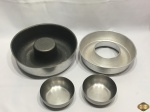 Lote composto de 2 bowls em aço inox e 2 formas de bolo pudim em alumínio. Medindo a forma maior 25,5cm de diâmetro x 7,5cm de altura.