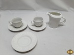 Lote composto de 2 xícaras e 3 pires de café em porcelana Wolff e 1 leiteira em porcelana branca.