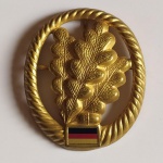 11. MILITÁRIA. Distintivo da Tropa de Infantaria da Bundeswehr, Forças Armadas da ALEMANHA. Produzido em metal dourado, mede 4,5 x 5,5 cm e traz a bandeira do país na parte inferior. 