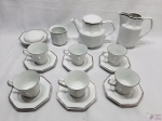 Jogo de chá com 10 peças em porcelana Schmidt facetada, friso prata. Composto de 6 xícaras com pires, bule, leiteira, manteigueira e açucareiro (sem tampa).