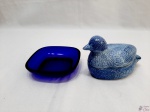 Lote de petisqueira em vidro azul cobalto e caixa na forma de ave em porcelana azul. Medindo a caixa 13cm x 7,5cm x 9,5cm de altura.