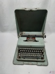 Antiga maquina de escrever em metal, no estojo. Necessita lubrificação.