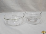 Lote composto de fruteira e forma de bolo pudim em vidro incolor. Medindo a forma 24,5cm de diâmetro x 8,5cm de altura.