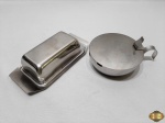 Lote composto de manteigueira e açucareiro em aço inox. Medindo o açucareiro 11,5cm de diâmetro x 4,5cm de altura.