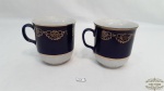2 Canecas em Porcelana Branca e Azul Cobalto com Friso Dourado.Medidas: 10 cm de altura e 9 cm de diametro.