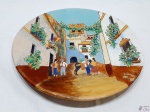 Medalhão em cerâmica vitrificada com imagem de casario. Medindo 36cm de diâmetro.