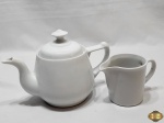 Lote composto de bule e leiteira em porcelana branca. Medindo o bule 17cm de altura.