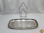 Lote composto de suporte para pendurar na forma de clips e travessa de peixe em aço inox Meridional. Medindo 52,5cm x 22,5cm