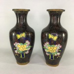 Antigo par de vasos CLOISONNÉ decorado com arranjos florais sobre fundo escuro. Presença de perda de esmalte na parte interna e pequenas marcas do tempo. Dimensões: 23 cm altura.