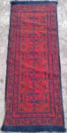 Antiga passadeira chinesa, confeccionada a mão, em lã e algodão, ancores predominantes vermelho e azul, com decoração geométrica. Med  140x52 cm.