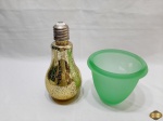 Lote composto de garrafa na forma de lampada em vidro colorido e cachepot em vidro verde. Medindo a garrafa 23,5cm de altura.