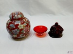 Lote composto de Buda sentado com peanha em madeira, potiche bola em porcelana floral, salva em vidro rubi.