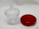 Lote composto de petisqueira em vidro vermelho e pequena compoteira em vidro moldado. Medindo a compoteira 15cm de altura x 10,5cm de diâmetro.
