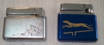 Dois isqueiros, um da marca APEX, e outro decorado com figura de cão de corrida sobre fundo azul. Largura: 4.5 a 4,8cm.  (Al91)  Estes itens  se encontram em Lavras -MG.