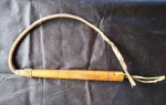 Chicote em couro cru trançado com cabo em madeira. Comprimento (cabo + couro): 1,00 m. (Al140)  Estes itens  se encontram em Lavras -MG.