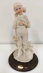 Escultura em resina representando menina com passarinho . Marca:  Assinado A. Belcari-1986 - Italia . Base em madeira .  Mede: 18 cm (Am)