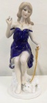 Belíssima Estatueta em porcelana policromada ao natural e filetes a ouro, representando  de jovem com seu cachorro . Mede: 20 cm 