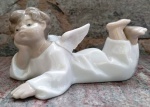 Estátua em porcelana de anjinho deitado  . Marca: LLADRÓ legítima numerada 4541 . Mede: 14 cm 