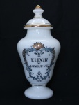 Pote de farmácia no feitio de balaústre em demi cristal opalinado em tom branco leitoso com ricos frisos dourados. Identificador ("ELIXIR DE LOUGUE VIE") em negro, emoldurado com arabescos também em dourado. Alt.: 32 cm. (Em função da fragilidade, recomendo o envio em caixa de isopor).