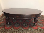 Antiga mesa de centro oval em madeira nobre, pés torneados. Med. 42x147x120 cm.