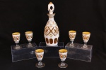 CRISTAL OVERLAY - Raro lote de delicada licoreira com 6 cálices em cristal Czecho, ricamente lapidados e pintados a mão com motivos florais policromados, fundo amarelo e detalhes dourados, base dos cálices incolor. Alt. maior 25 cm e menor 8 cm.
