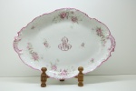 VELHO PARIS (Vieux Paris) SEC XIX, linda travessa oval em porcelana com recortada, decorada com delicadas rosas e folhagens, ao centro monograma "AR". Med. 5x43x30 cm.