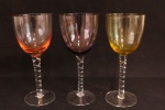 DEMI CRISTAL - Conjunto de taças vinho com base e haste incolor, decorada em relevo, bojo colorido, nas cores  amarela, rose e bordo. 19x8 cm.