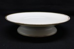 LIMOGES - Prato para bolo com pé alto em delicada porcelana Limoges (France), na cor branca com borda dourada. Med. 5x22 cm. Marcada no fundo.