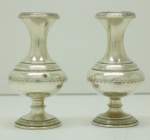 PRATA DE LEI - Par de graciosas floreiras em prata brasileira, contrastada 800 mls, base circular, delicados trabalhos lavrados e cinzelados. Alt. 12 cm e peso 183 gr. Possuem amassados. PEÇA NÃO EXPOSTA NO LEILÃO, A MESMA ENCONTRA-SE NO COFRE DO BANCO.