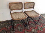 Par de cadeiras modelo Cesca com estrutura em ferro pintado de preto e assento e encosto em palhinha. Em bom estado de conservação. Modelo atribuído e desenhado em 1928 pelo designer norte-americano de origem húngara, MARCEL BREUER. Med. 77x50x45 cm.