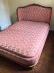 Cama de casal em estilo inglês, em madeira nobre e forrada em tecido floral. Med. 117x160x212 cm.